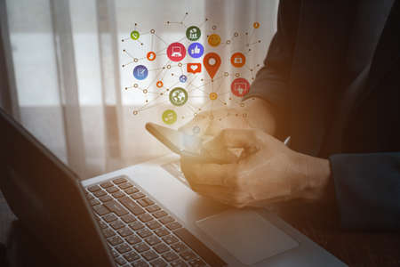 man using smartphone with social web icon popup on the phone in living room at home, man using...