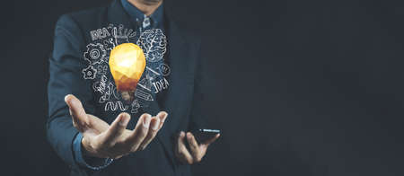 Businessman holding a light bulb giving ideas, ideas, information, news and trading stocks. concept,...