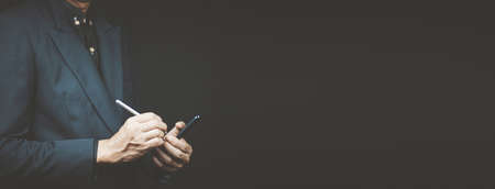 Close up of businessman in blue suit using tablet computer .の写真素材