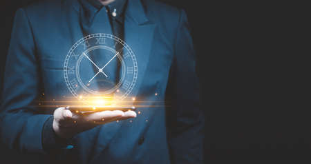 Businessman holding clock. Business time management .の写真素材