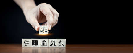Wooden cube block shape with icon law legal justice. Law business and justice banner. Modern stacking cube block design with court, scale and justice symbols on smart dark background and copy space.の写真素材