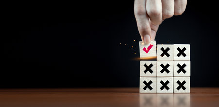 right and wrong icon on wooden cube with man hand select correct icon on dark background The right...