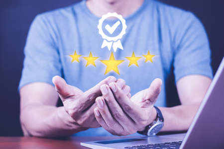 Hand shows the sign of the top service Quality assurance 5 star, Guarantee, Standards, ISO certification and standardization concept.の写真素材