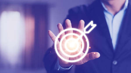 Man holding virtual dartboard and arrow with copy space for setup business objective target concept.の写真素材