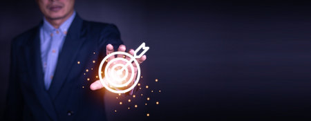 Businessman holding virtual dartboard and arrow with copy space for setup business objective target concept.の写真素材