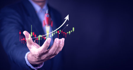 businessman or stock trader analyzing stock graph chart, side view stock trader using laptop to buy...