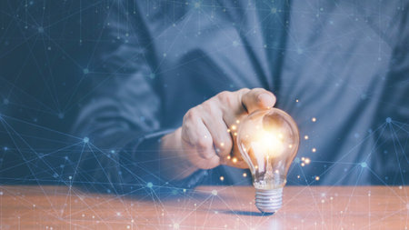 Businessman touching a bright light bulb. Concept of Ideas for presenting new ideas Great inspiration and innovation new beginning.の写真素材