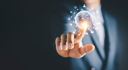 Businessman holding virtual world with icons and connection line for data exchange from globalization innovation technology and global business concept.の写真素材