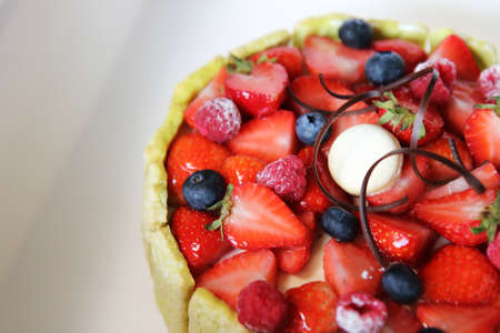 Mix fruit tart with strawberries, blueberries, rasberry and macaroon in a white box