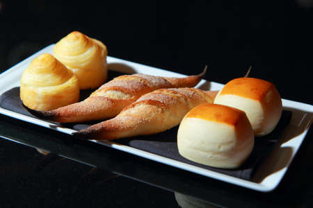 Breads on a plate isolated on black backgroundの写真素材