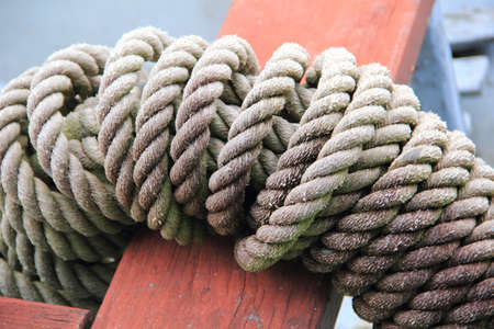 Thick Hemp Marine Rope Folded Helix lie on  wooden seat bar while on a Military Battleship Paddle Rescue Boatの写真素材