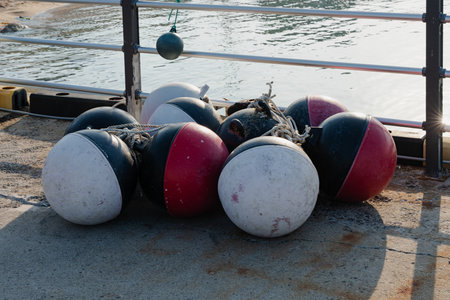 Pile of colorful fishing buoys on a dock by the water