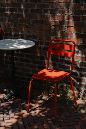 Outdoor Sitting with Red Chair and Brick Wall Backgroundの写真素材