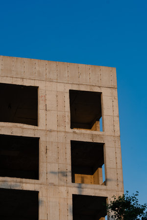Abandoned building with symmetrical window openings against clear skyの写真素材