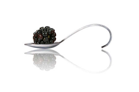 blackberry on curved spoon with reflection make heart shape isolated on whiteの写真素材