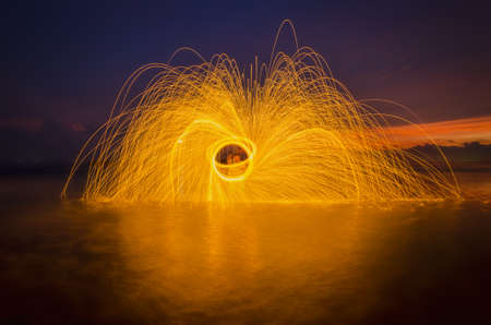 Activity time play steel wool at lighthouse sunset beautiful.の写真素材