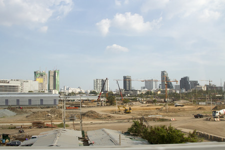 Inside place for many tall buildings under construction and cranes under a blue skyの写真素材