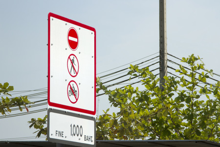 Do not walk and do not ride a motorcyclewarning sign against blue skyの写真素材