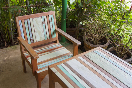 Table with wooden chair with green tree surrounded.の写真素材