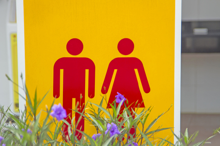 Male red-female toilet symbol, yellow background with purple flowersの写真素材