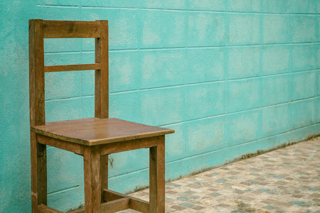 Old wooden chair on blue wall background