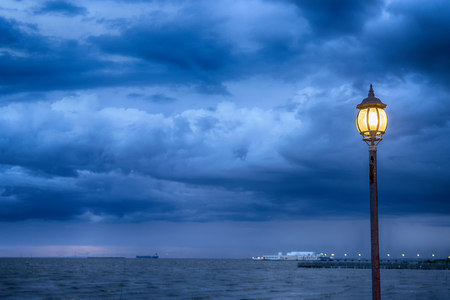 Light Post at nigth near sea with stom backgroundの写真素材