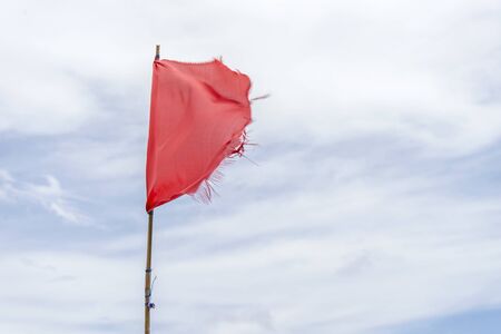 Red flag warning flags wind blue skyの写真素材
