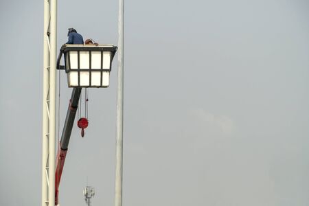 Use crane to lift the light bulbs to repair the light poleの写真素材