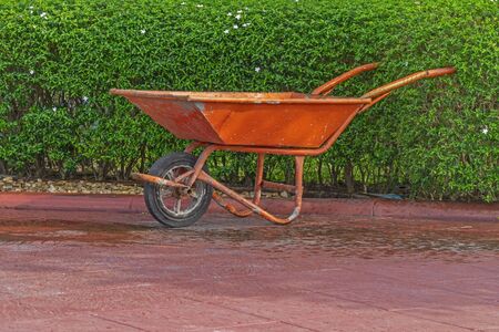 Cement cart red In the garden on green backgroundの写真素材