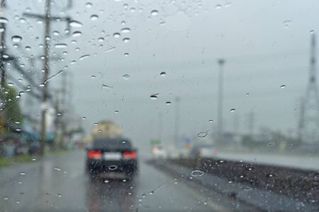 Driving in the rain there are water drops in the glass.

and  see a black car blur の写真素材