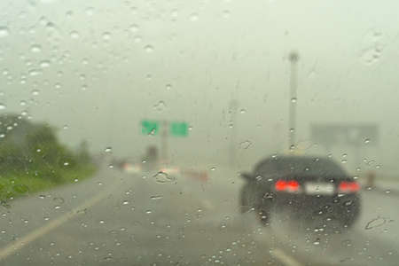 Driving in the rain there are water drops in the glass.の写真素材