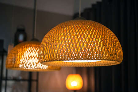 Woven bamboo lamp with black gray steel frame backgroundの写真素材