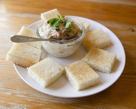 Tuna fish sandwich with tomatoes, lettuce and mayonnaise on a wooden boardの写真素材