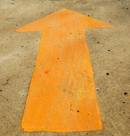 A forwarded yellow arrow on the roadの写真素材