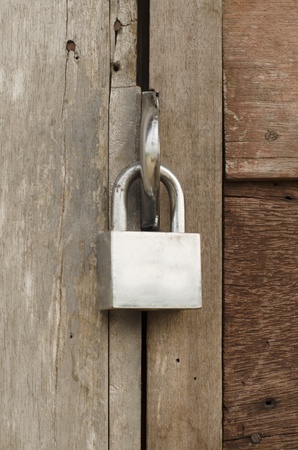 The padlock locking the wooden doorの写真素材