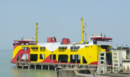 Yellow ferry with mountain and cloudy sky at background in Georgetown, Penang, Malaysiaのeditorial素材