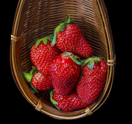 Fresh Strawberry in a wooden basket isolated on black の写真素材
