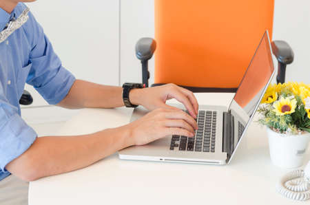 businessman typing on laptop in an office