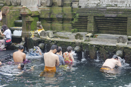 BALI, INDONESIA - JUNE 9: Balinese Hindu families come to the sacred springs of Tirta Empul in Bali, Indonesia to pray and cleanse their soul on June 9, 2014.のeditorial素材