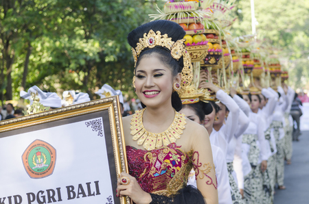 DENPASAR, BALI, INDONESIA - JUNE 18: Unidentified dancer of Balinese in colorful dresses variety on the parade at Bali Art Festival on June 18, 2014 in Denpasar, Indonesiaのeditorial素材