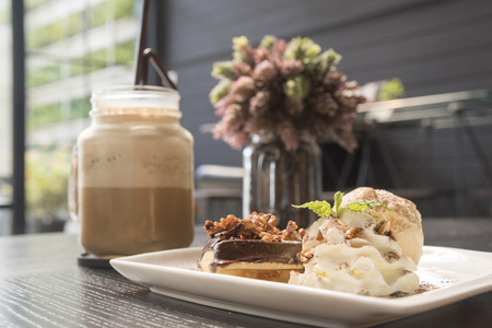 A slice of rich chocolate cake with ice cream and coffeeの写真素材