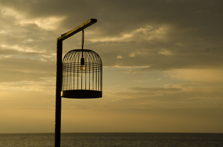 bird cage with the sea sunsetの写真素材