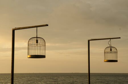 bird cage with the sea sunsetの写真素材