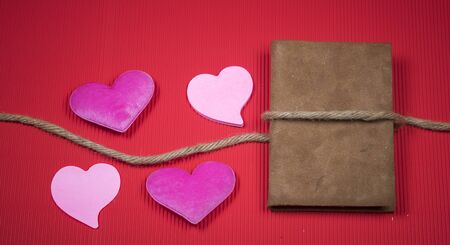 Valentine background with sewed pillow hearts row border on red clothespins. Happy lovers day card mockup, copy spaceの写真素材