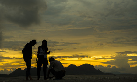 silhouette of people at landscape sunset in the seaの写真素材