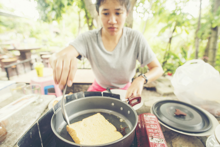 Asian teen girls are toasting bread for breakfast.の写真素材
