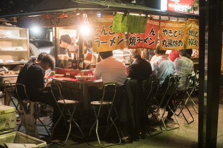 FUKUOKA, JAPAN - SEPTEMBER 29, 2017: People eating Yatai mobile food stall at night in Fukuoka, Kyushu, Japanのeditorial素材