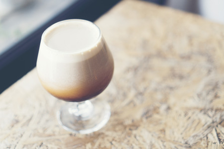 frothy sparkling nitro cold brew ready to be served at coffee shop bar environment background....