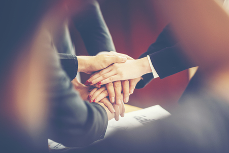 business people join hand while meeting in office