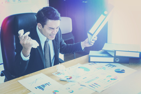 Concept of stress and frustration of a businessman with laptopの写真素材